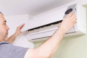 a man removes the cover of the air conditioner for the cleaning indoors