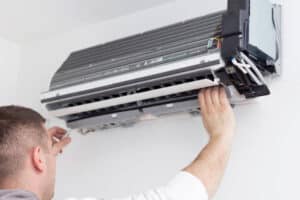 Young man installing air conditioner in an apartment.